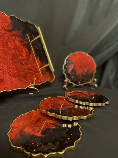 A set of colorful DIY resin coasters with embedded flowers and glitter, displayed on a wooden table.