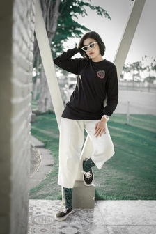 A skate outfit ideas outfit, featuring a black graphic tee, ripped jeans, and high-top sneakers,