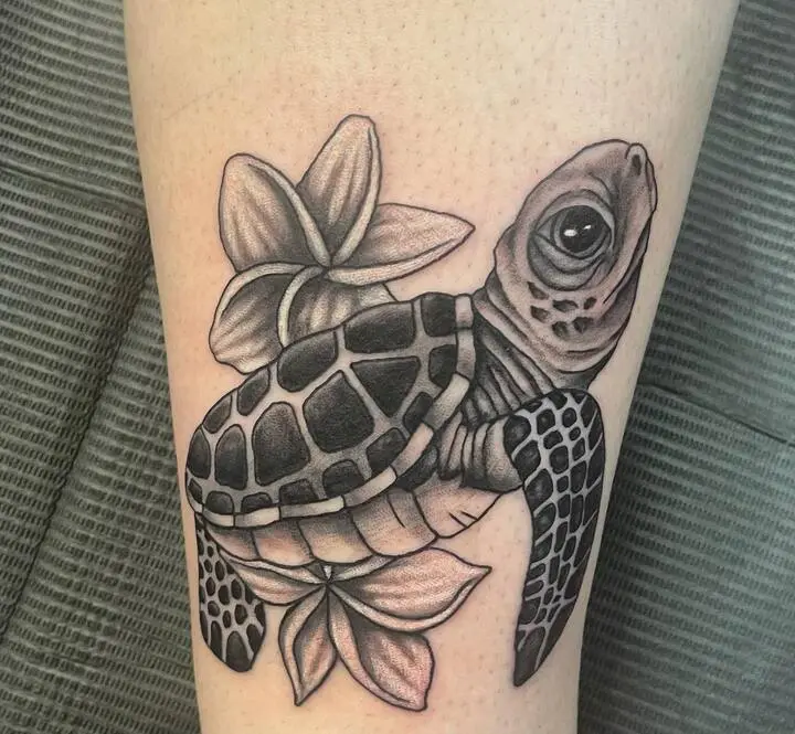 A detailed sea turtle tattoo on a person's forearm, featuring a realistic green sea turtle swimming through an ocean scene with coral and waves, rendered in vibrant blues and greens.